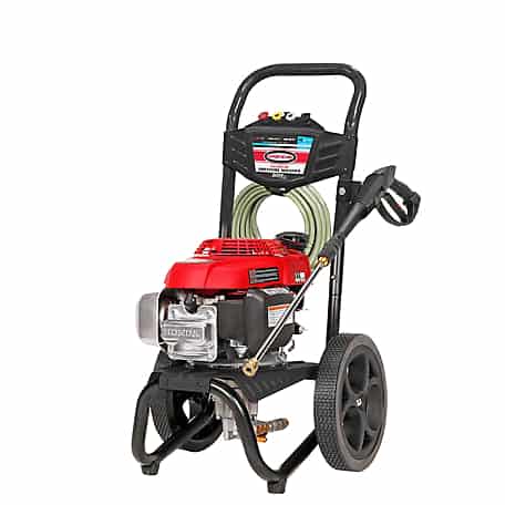 An industrial-grade red and black Honda pressure washer with large wheels, a hose wrapped around the handle, and a spray gun attachment.