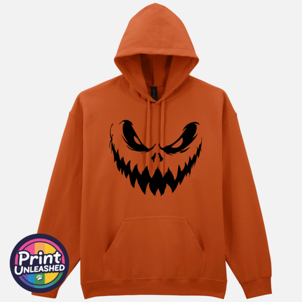 225 tex ora Sinister pumpkin face with narrowed eyes and sharp jagged teeth on a Texas Orange Softstyle Hoodie - Print Unleashed