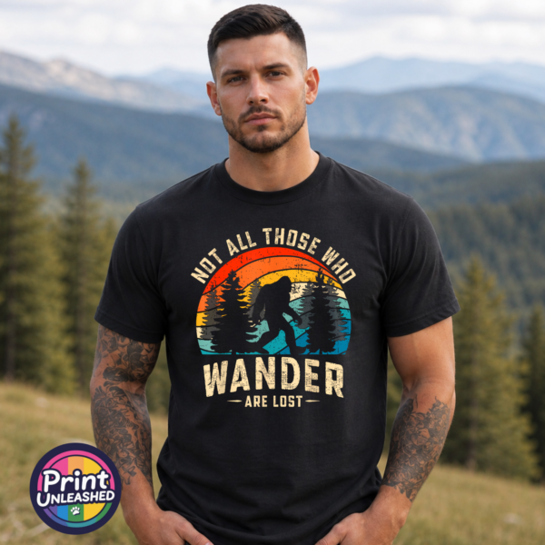 Bigfoot Wander black model Bigfoot walking among pine trees against a distressed retro sunset on a black unisex T-shirt model - Print Unleashed
