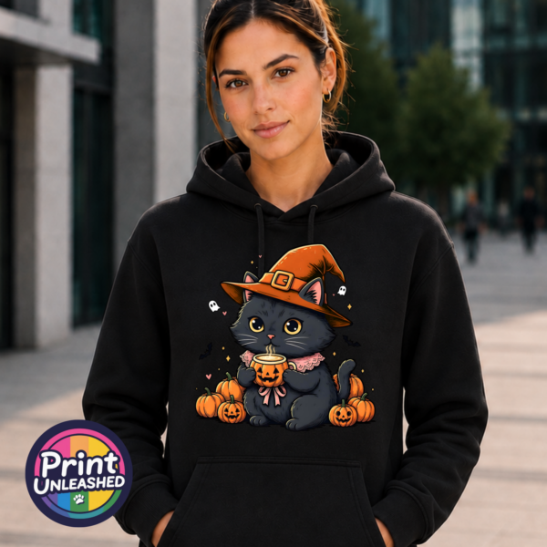 Cute black cat wearing an orange witch hat and pink collar, holding a steaming pumpkin mug among pumpkins, tiny ghosts and bats, printed on an Everyday Hoodie female model - Print Unleashed