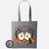 Two ghosts in witch hats holding orange mugs beside a campfire, with a black cat, pumpkins and autumn trees, printed on a tote bag slate - Print Unleashed