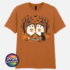 Two ghosts in witch hats holding orange mugs beside a campfire, with a black cat, pumpkins and autumn trees, printed on a unisex T-shirt texas orange - Print Unleashed