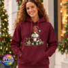 Model wearing a Classic Hoodie featuring a Christmas gonk in a red snowflake hat holding hot chocolate piled with marshmallows, surrounded by gingerbread stars and holly - Print Unleashed