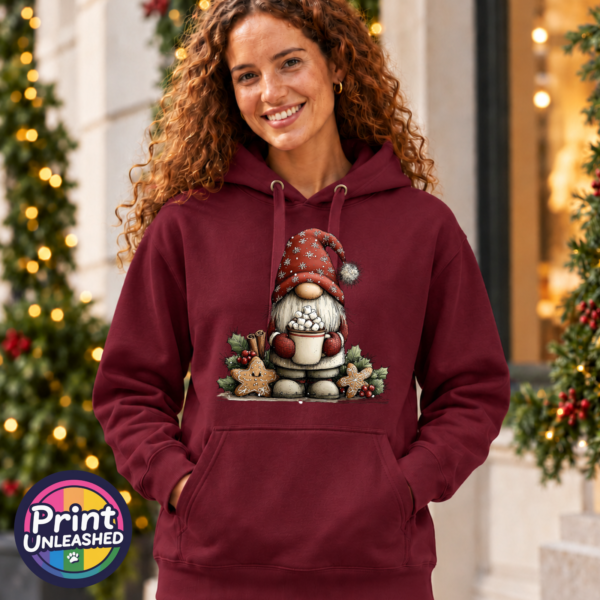 Classic Gonk Hot Choc pepper red model female Model wearing a Classic Hoodie featuring a Christmas gonk in a red snowflake hat holding hot chocolate piled with marshmallows, surrounded by gingerbread stars and holly - Print Unleashed