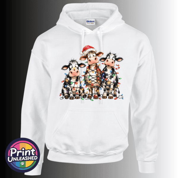 Cow Lights hoodie Three wide-eyed Christmas cows tangled in colourful lights, one wearing a Santa hat and another holding a candy cane, printed on a white unisex hoodie - Print Unleashed