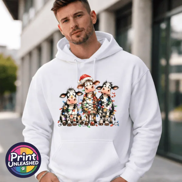 Cow Lights hoodie model male Three wide-eyed Christmas cows tangled in colourful lights, one wearing a Santa hat and another holding a candy cane, printed on a white unisex hoodie male model - Print Unleashed