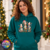 Three Christmas cows tangled in colourful lights, one wearing a Santa hat and another holding a candy cane, printed on a classic hoodie female model - Print Unleashed