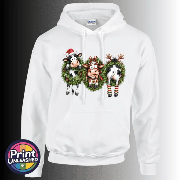 Three Christmas cows in festive wreaths, one wearing a Santa hat and another facing backwards with antlers and striped leg warmers, printed on a white unisex hoodie - Print Unleashed