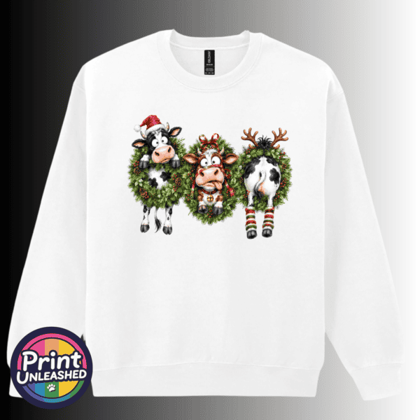 Cow Wreath sweat Three Christmas cows in festive wreaths, one wearing a Santa hat and another facing backwards with antlers and striped leg warmers, printed on a white unisex sweatshirt - Print Unleashed