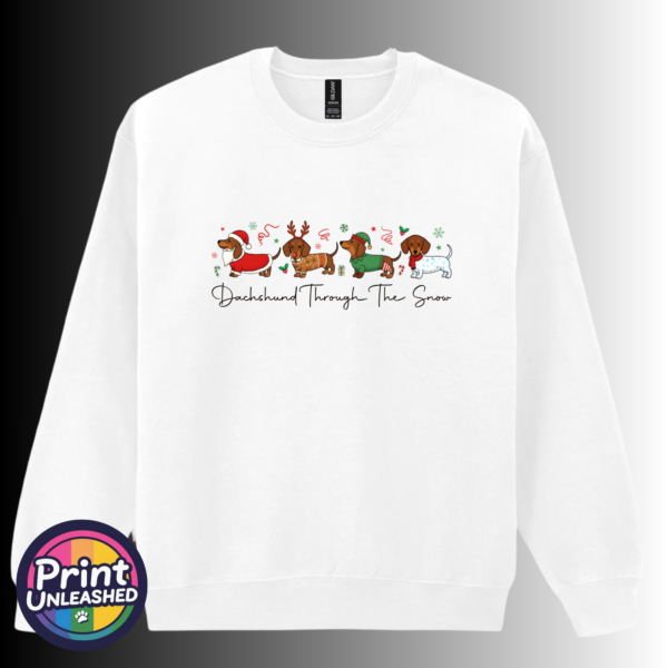 Four dachshunds dressed as Santa, a reindeer, an elf and a snowman above Dachshund Through the Snow wording, printed on a white unisex sweatshirt - Print Unleashed