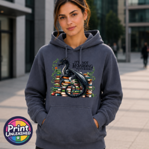 Black dragon guarding stacks of colourful books surrounded by curling green vines, with It’s Not Hoarding If It’s Books wording, printed on an Everyday Hoodie model - Print Unleashed