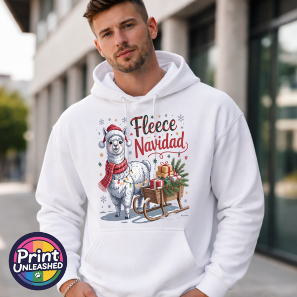 Christmas llama wearing a red knitted hat, tartan scarf and fairy lights beside a gift-filled sleigh, with Fleece Navidad wording on a white unisex hoodie male model - Print Unleashed