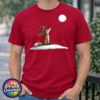 Fox wearing a crown of holly and berries gazing at a full moon from a snowy hill, printed on a cherry red premium unisex T-shirt male model - Print Unleashed