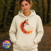 Fox in profile with its russet fur blending into a sweeping curve of orange, red and golden autumn leaves printed on a softstyle hoodie model - Print Unleashed