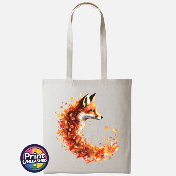 Fox in profile with its russet fur blending into a sweeping curve of orange, red and golden autumn leaves printed on a natural tote bag - Print Unleashed
