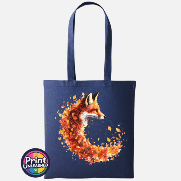 Fox in profile with its russet fur blending into a sweeping curve of orange, red and golden autumn leaves printed on a tote bag in oxford navy - Print Unleashed