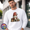 Christmas gonk in a red snowflake-patterned hat holding hot chocolate piled with marshmallows, surrounded by gingerbread stars and holly, printed on a white unisex sweatshirt male model - Print Unleashed