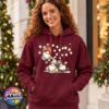 Classic Hoodie featuring three Christmas gonks in red and grey spotted hats, with one hanging from strings of warm glowing lights above two seated companions, model image - Print Unleashed