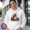 Christmas gonk in a red star-patterned hat beside a cream crescent moon and hanging gold star, with holly and baubles, printed on a white unisex hoodie female model - Print Unleashed