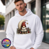 Christmas gonk in a red star-patterned hat beside a cream crescent moon and hanging gold star, with holly and baubles, printed on a white unisex hoodie male model - Print Unleashed