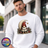 Christmas gonk in a red star-patterned hat beside a cream crescent moon and hanging gold star, with holly and baubles, printed on a white unisex sweatshirt male model - Print Unleashed