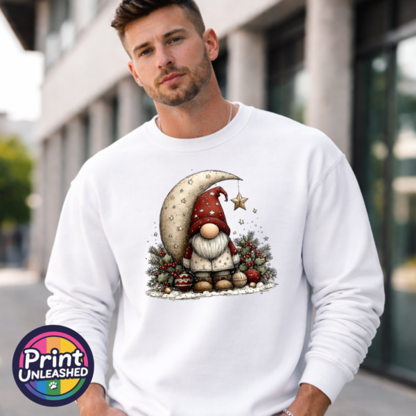 Christmas gonk in a red star-patterned hat beside a cream crescent moon and hanging gold star, with holly and baubles, printed on a white unisex sweatshirt male model - Print Unleashed