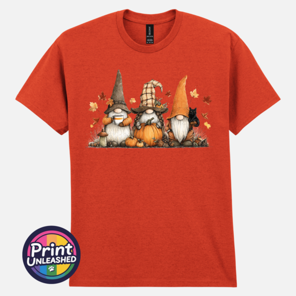 Three autumn gonks in witch hats with pumpkins, a takeaway cup, a black cat and falling leaves printed on a unisex T-shirt antique orange - Print Unleashed