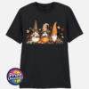 Three autumn gonks in witch hats with pumpkins, a takeaway cup, a black cat and falling leaves printed on a unisex T-shirt black - Print Unleashed