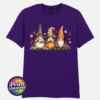 Three autumn gonks in witch hats with pumpkins, a takeaway cup, a black cat and falling leaves printed on a unisex T-shirt dark purple - Print Unleashed