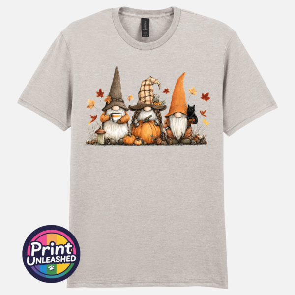 Three autumn gonks in witch hats with pumpkins, a takeaway cup, a black cat and falling leaves printed on a unisex T-shirt ice grey - Print Unleashed