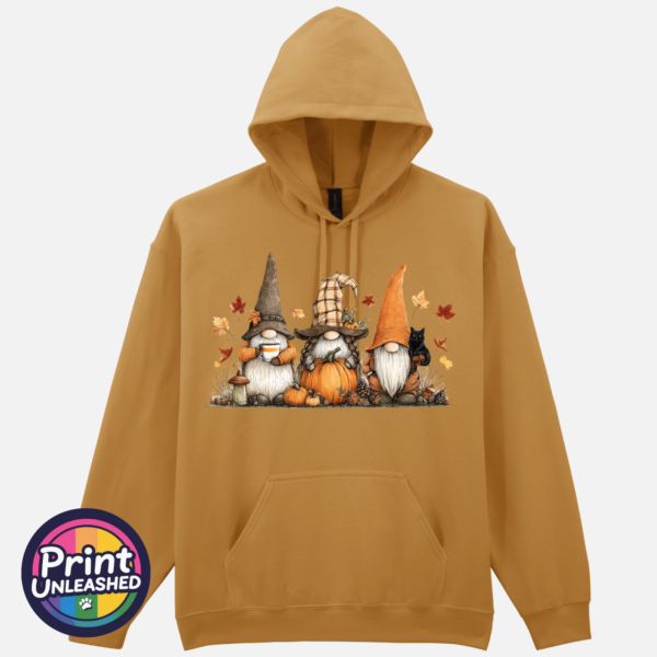 Three autumn gonks in tall pointed hats with pumpkins, a takeaway cup, a black cat and falling leaves printed on a mustard softstyle hoodie - Print Unleashed