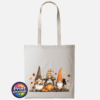 Three autumn gonks in tall pointed hats with pumpkins, a takeaway cup, a black cat and falling leaves printed on a natural tote bag - Print Unleashed