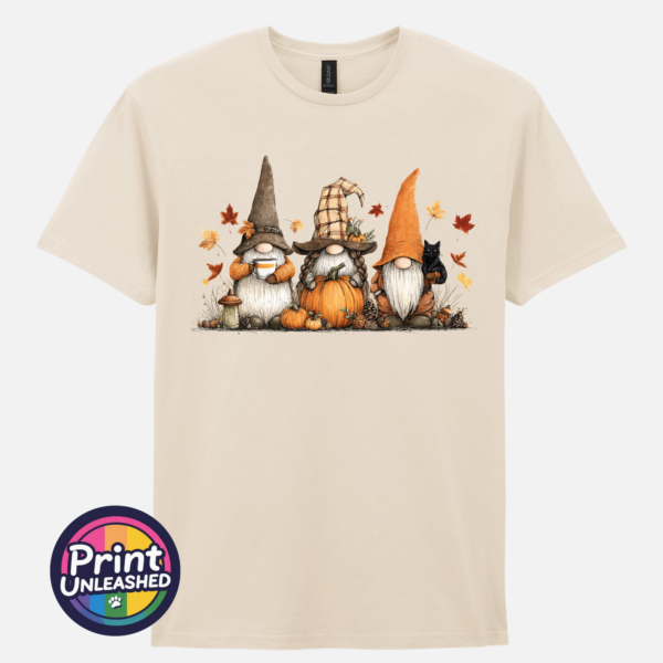 Three autumn gonks in witch hats with pumpkins, a takeaway cup, a black cat and falling leaves printed on a unisex T-shirt natural - Print Unleashed