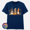Three autumn gonks in witch hats with pumpkins, a takeaway cup, a black cat and falling leaves printed on a unisex T-shirt navy - Print Unleashed