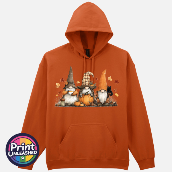 Three autumn gonks in tall pointed hats with pumpkins, a takeaway cup, a black cat and falling leaves printed on a texas orange softstyle hoodie - Print Unleashed