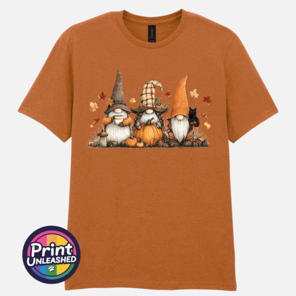 Three autumn gonks in witch hats with pumpkins, a takeaway cup, a black cat and falling leaves printed on a unisex T-shirt texas orange - Print Unleashed