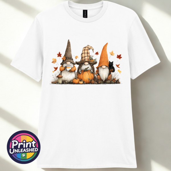 Three autumn gonks in witch hats with pumpkins, a takeaway cup, a black cat and falling leaves printed on a unisex T-shirt white - Print Unleashed