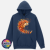 Hedgehog surrounded by swirling orange, red and golden autumn leaves on a softstyle hoodie in blue dusk - Print Unleashed