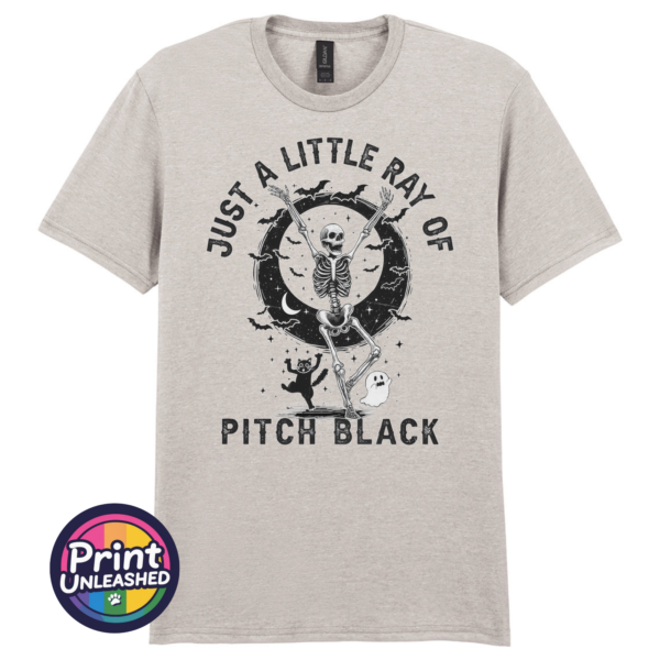 Just A Little Ray of Pitch Black ice grey Ice grey unisex T-shirt featuring a dancing skeleton with bats, a crescent moon, stars, a cat and ghost beneath Just a Little Ray of Pitch Black lettering - Print Unleashed