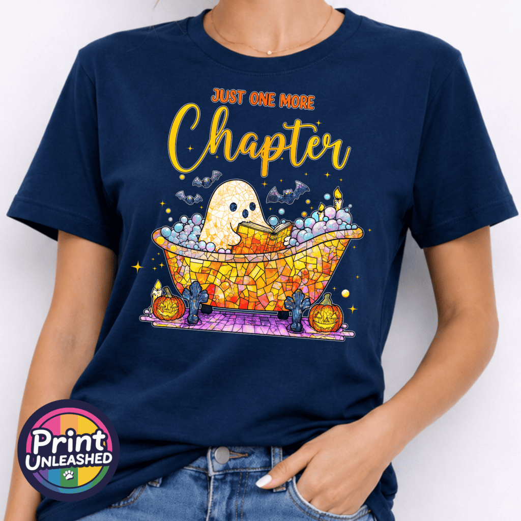 Mosaic-style ghost reading in a colourful bubble bath surrounded by bats, candles and pumpkins, with Just One More Chapter wording, printed on a unisex T-shirt navy model - Print Unleashed
