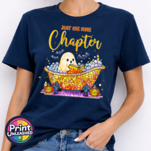 Mosaic-style ghost reading in a colourful bubble bath surrounded by bats, candles and pumpkins, with Just One More Chapter wording, printed on a unisex T-shirt navy model - Print Unleashed