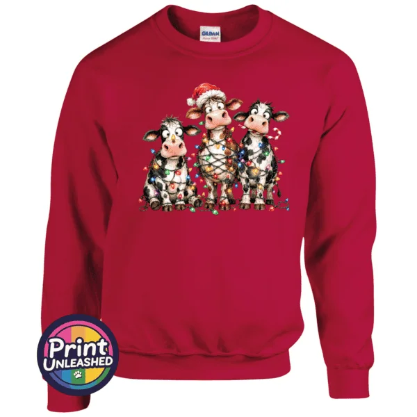 Three Christmas cows tangled in colourful lights, one wearing a Santa hat and another holding a candy cane, printed on a cherry red unisex sweatshirt - Print Unleashed