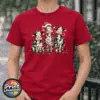 Three Christmas cows tangled in colourful lights, one wearing a Santa hat and another holding a candy cane, printed on a cherry red premium unisex T-shirt female model - Print Unleashed