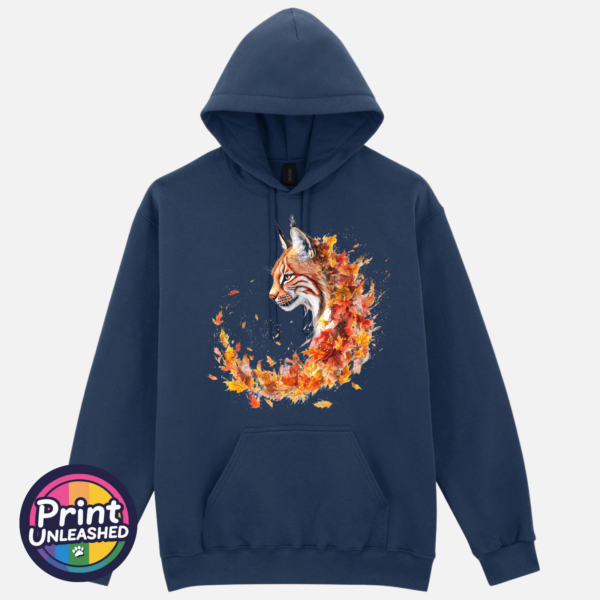 Lynx with tufted ears and an amber eye emerging from swirling orange, red and golden autumn leaves on a softstyle hoodie blue dusk - Print Unleashed