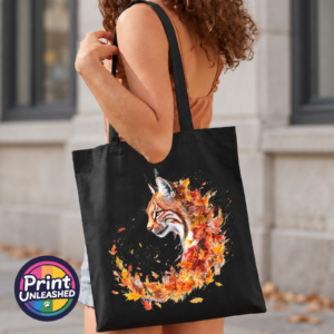 Lynx with tufted ears and an amber eye emerging from swirling orange, red and golden autumn leaves on a tote bag model - Print Unleashed