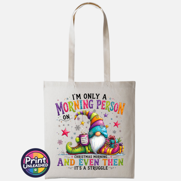Morning Person Gonk natural Colourful Christmas gonk holding a steaming coffee mug beside presents, with funny Christmas morning person wording, printed on a natural tote bag - Print Unleashed
