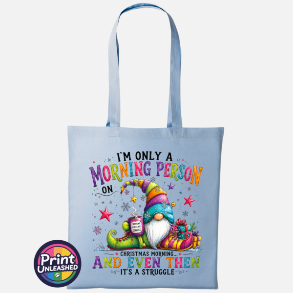 Morning Person Gonk sky Colourful Christmas gonk holding a steaming coffee mug beside presents, with funny Christmas morning person wording, printed on a sky tote bag - Print Unleashed