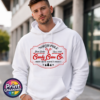 Vintage North Pole Candy Cane Co. design with crossed candy canes, decorative red borders, fir trees and snowflakes, printed on a white unisex hoodie male model - Print Unleashed