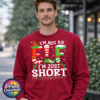 I’m not an elf I’m just short wording with red and green elf-style letters, striped stockings, holly and Christmas lights printed on a cherry red unisex sweatshirt male model - Print Unleashed