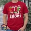 I’m not an elf I’m just short wording with red and green elf-style letters, striped stockings, holly and Christmas lights printed on a cherry red premium unisex T-shirt male model - Print Unleashed